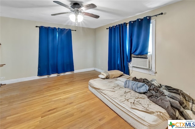 bedroom featuring hardwood / wood-style floors, ceiling fan, and cooling unit