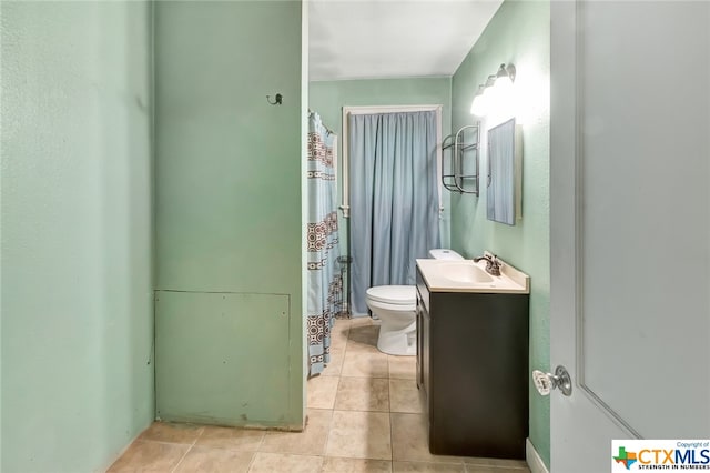 bathroom with toilet, vanity, and tile patterned floors