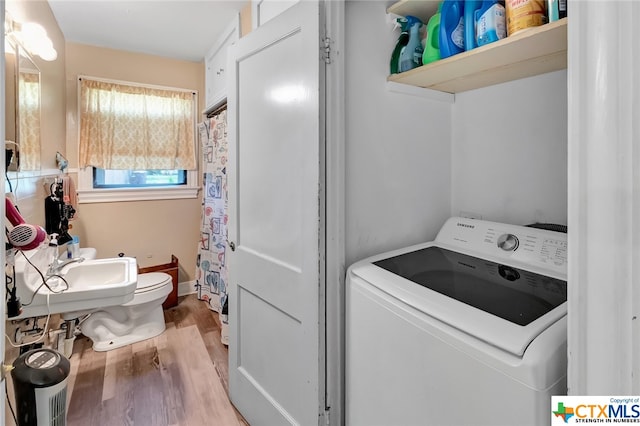 laundry area with sink, light wood-type flooring, and washer / clothes dryer