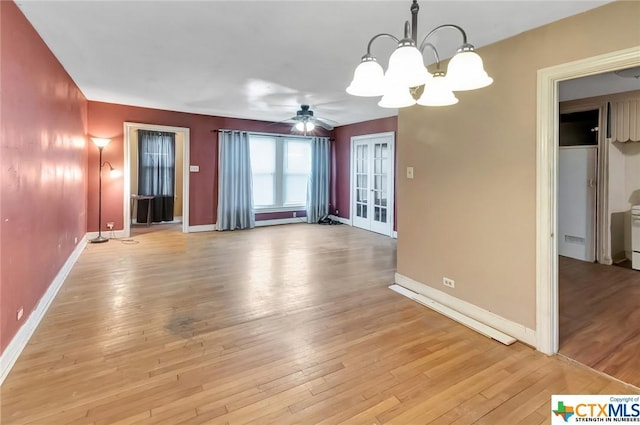 1005 Macarthur St, Victoria, TX 77901 - unfurnished living room with a chandelier, light wood-type flooring, baseboards, ceiling fan, and french doors