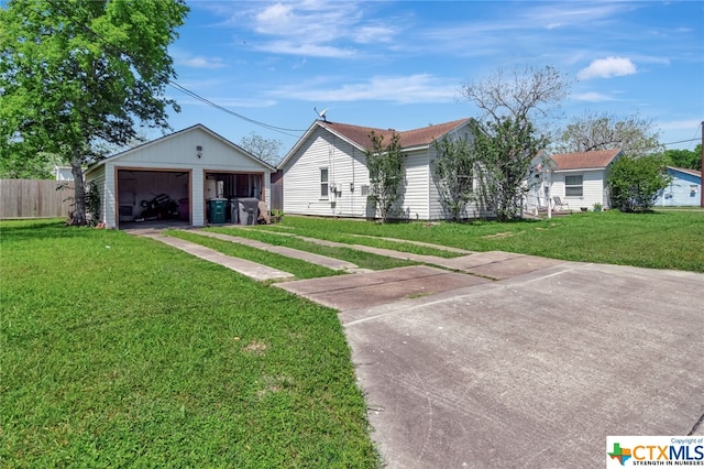 view of front facade featuring a garage, a front lawn, and an outbuilding