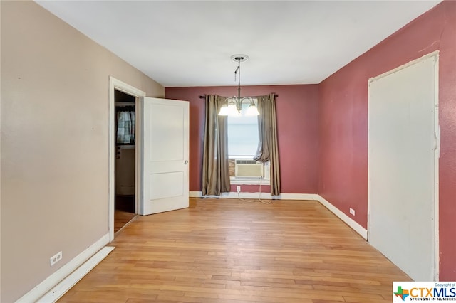 unfurnished dining area with light wood-type flooring, cooling unit, and a notable chandelier