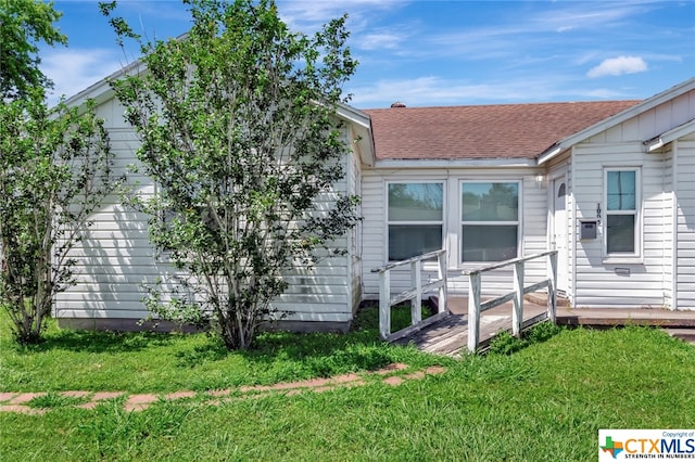 rear view of house featuring a lawn and a wooden deck