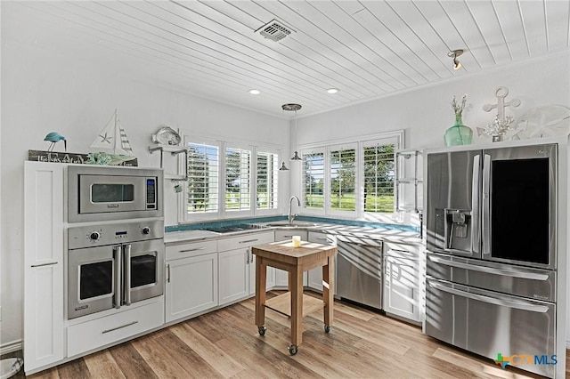 25 Augusta Cir, Aransas Pass, TX 78336 - kitchen with stainless steel appliances, wooden ceiling, white cabinetry, light wood-type flooring, and pendant lighting