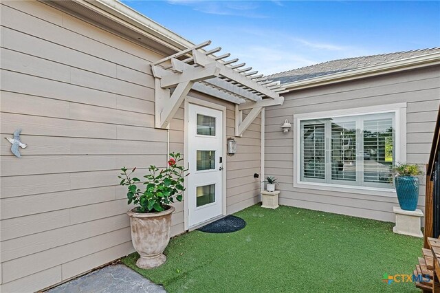 25 Augusta Cir, Aransas Pass, TX 78336 - property entrance featuring a pergola and a lawn