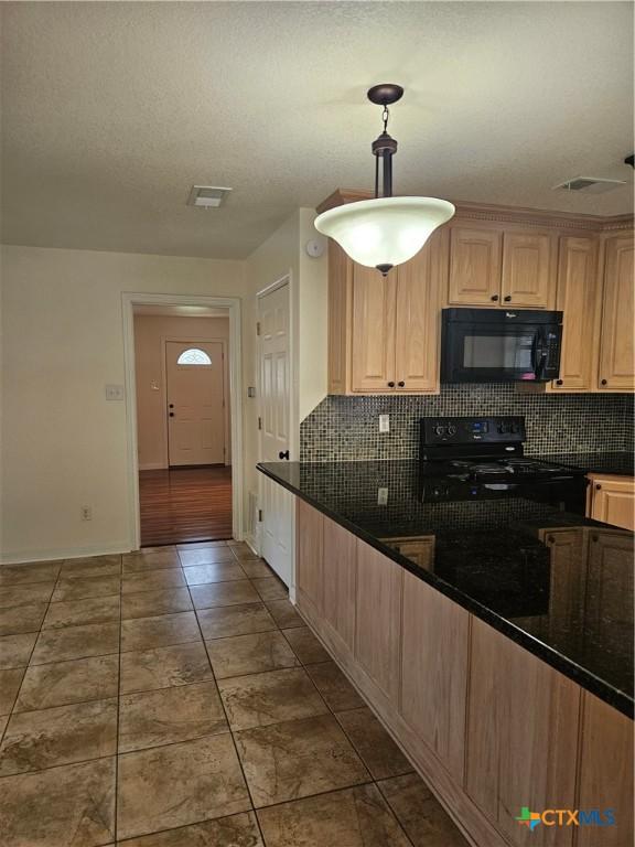 kitchen featuring black appliances, backsplash, light brown cabinets, decorative light fixtures, and baseboards