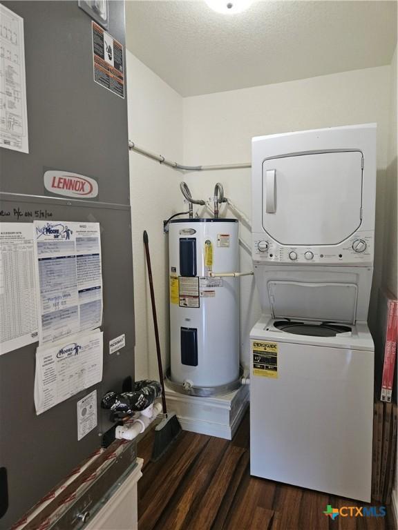 utilities featuring stacked washer / drying machine, electric water heater, and heating unit