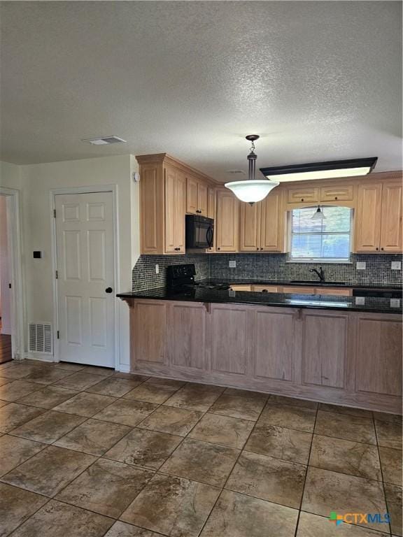 kitchen with backsplash, dark countertops, stove, and black microwave
