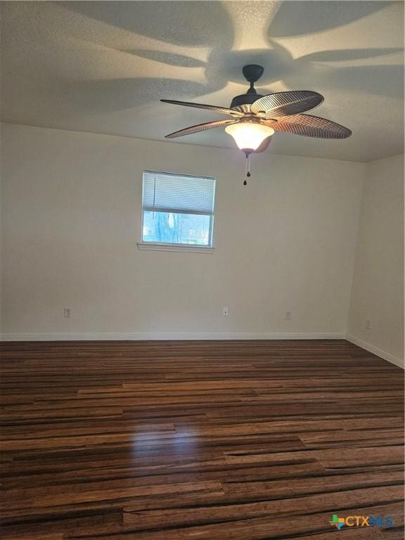 unfurnished room with dark wood-style flooring, baseboards, and ceiling fan