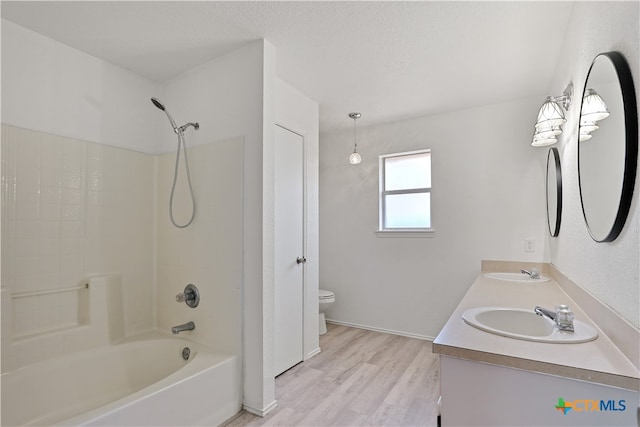 full bathroom with bathing tub / shower combination, vanity, hardwood / wood-style flooring, and toilet