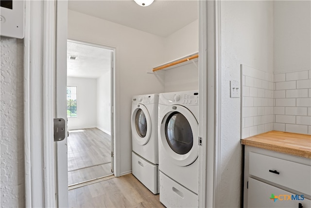 washroom featuring light hardwood / wood-style floors and washing machine and clothes dryer