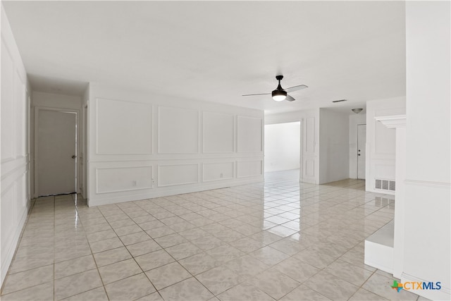 tiled spare room featuring ceiling fan