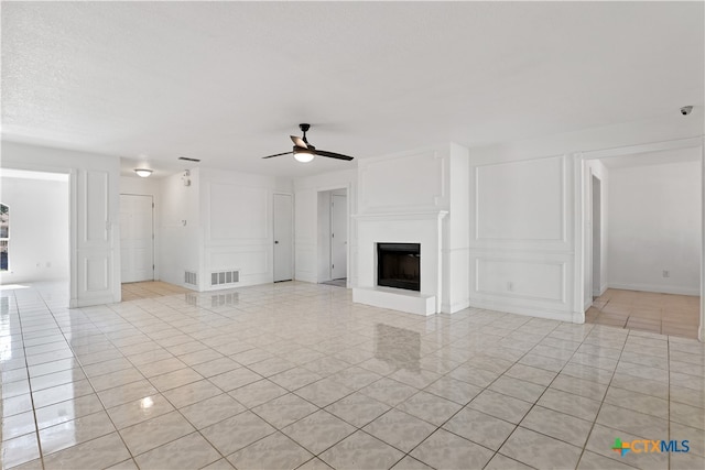 unfurnished living room with light tile patterned floors and ceiling fan