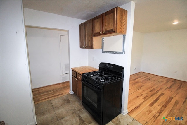 kitchen featuring black gas stove and dark hardwood / wood-style flooring