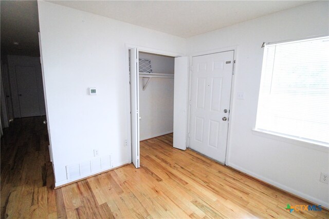 unfurnished bedroom with a closet and light hardwood / wood-style flooring