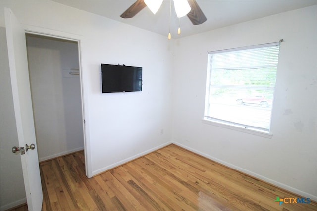 empty room with hardwood / wood-style flooring and ceiling fan