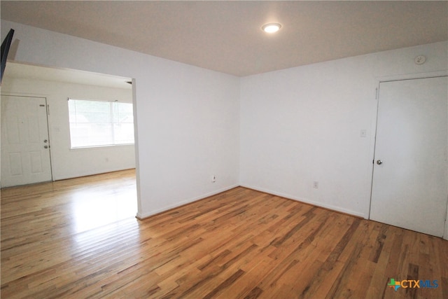 unfurnished room with wood-type flooring