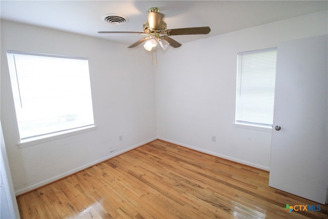 empty room with ceiling fan and light hardwood / wood-style flooring