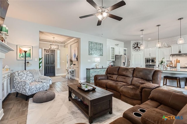 living room featuring light wood-style floors, baseboards, and ceiling fan