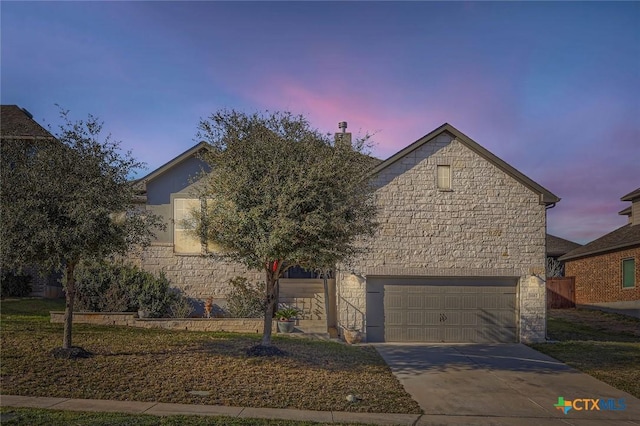 view of property hidden behind natural elements with a garage, stone siding, concrete driveway, and a chimney