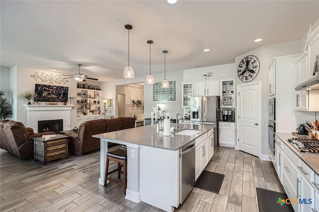 kitchen featuring a sink, stainless steel appliances, white cabinets, and wood tiled floor