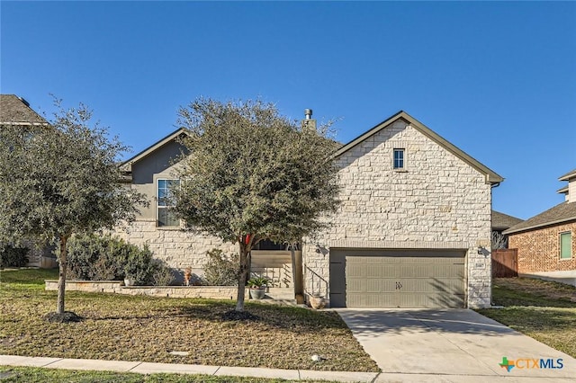 obstructed view of property with stone siding, an attached garage, and driveway