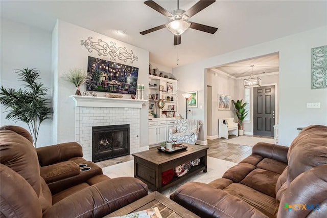 living room featuring baseboards, a ceiling fan, and a fireplace