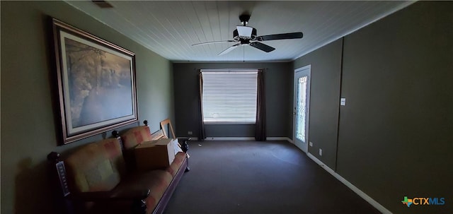 living area featuring dark colored carpet and ceiling fan