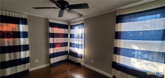 spare room with ceiling fan, crown molding, dark hardwood / wood-style floors, and a textured ceiling