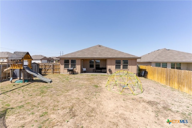 back of property with a patio, a playground, and a fenced backyard