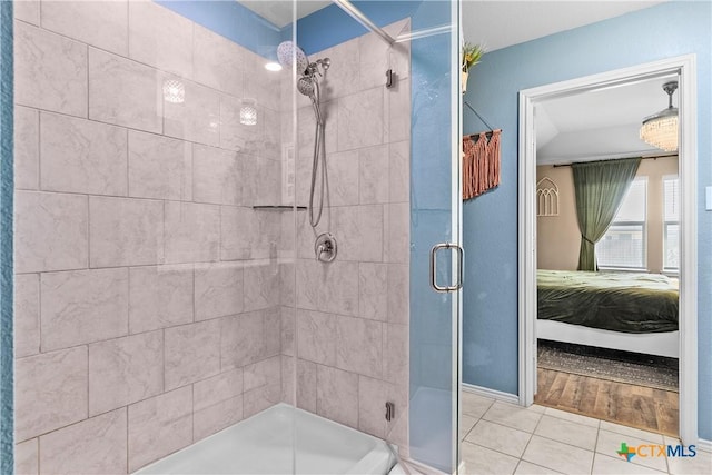 ensuite bathroom featuring tile patterned flooring, connected bathroom, and a stall shower