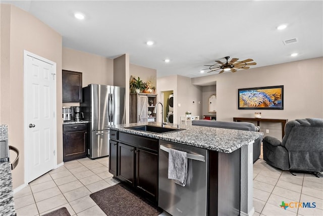 kitchen with visible vents, open floor plan, light stone counters, appliances with stainless steel finishes, and a sink