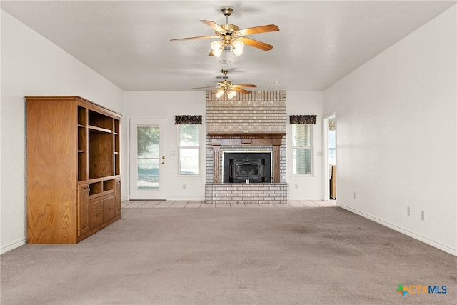 unfurnished living room featuring light carpet, a brick fireplace, and ceiling fan