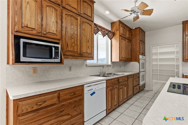 kitchen featuring sink, white appliances, light tile patterned floors, ceiling fan, and backsplash