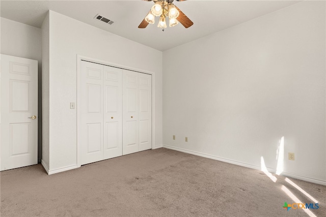 unfurnished bedroom featuring a closet, ceiling fan, and carpet flooring