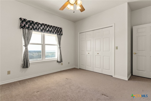 unfurnished bedroom with ceiling fan, light colored carpet, and a closet