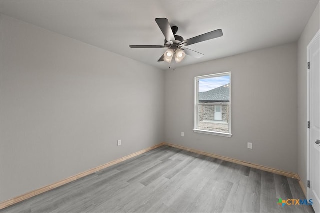empty room with a ceiling fan, wood finished floors, and baseboards
