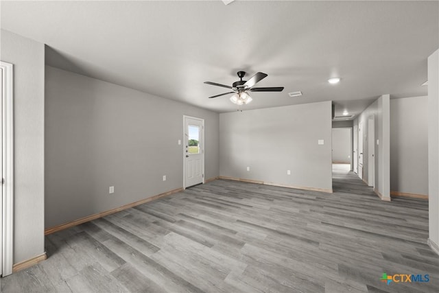 unfurnished living room featuring baseboards, visible vents, wood finished floors, and a ceiling fan