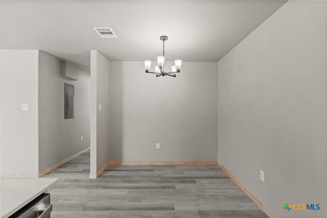 unfurnished dining area featuring a chandelier, visible vents, electric panel, and baseboards