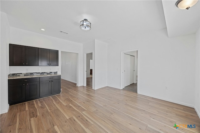 kitchen with dark brown cabinetry and light wood-type flooring