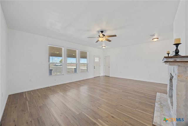 unfurnished living room with ceiling fan and light wood-type flooring