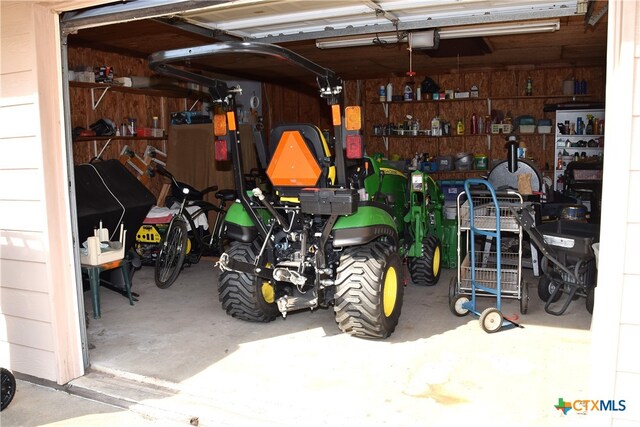 garage with a garage door opener and wooden walls