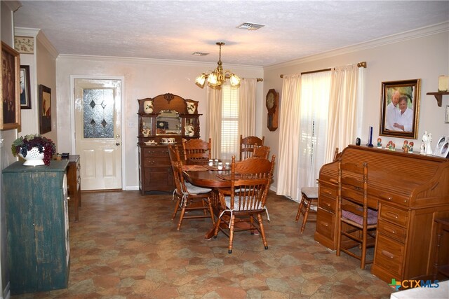 dining room featuring a chandelier, a textured ceiling, and ornamental molding