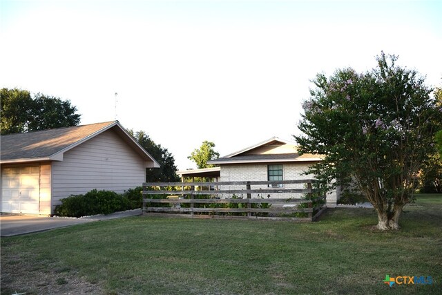 view of side of home with a garage and a lawn