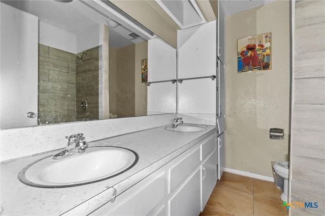 bathroom with toilet, tile patterned flooring, vanity, and walk in shower