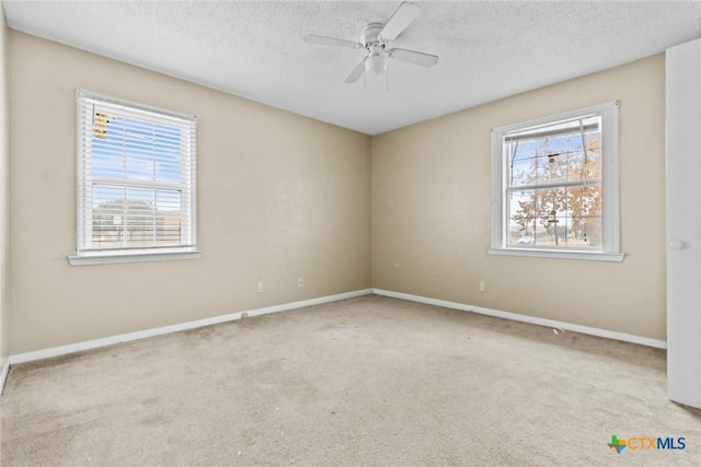 carpeted spare room featuring ceiling fan and a textured ceiling