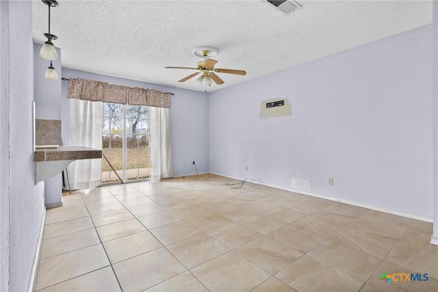 empty room featuring ceiling fan, light tile patterned flooring, and a textured ceiling