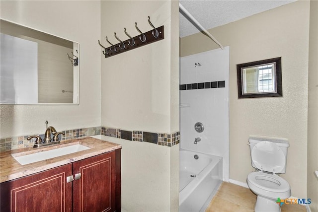 full bathroom featuring tile patterned flooring, a textured ceiling, toilet, vanity, and tiled shower / bath