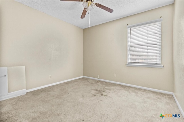 carpeted empty room featuring ceiling fan and a textured ceiling