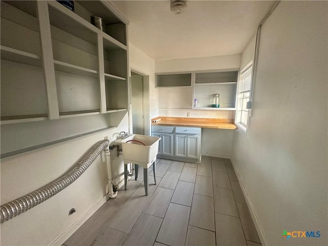 interior space with butcher block countertops, white cabinetry, and light wood-type flooring